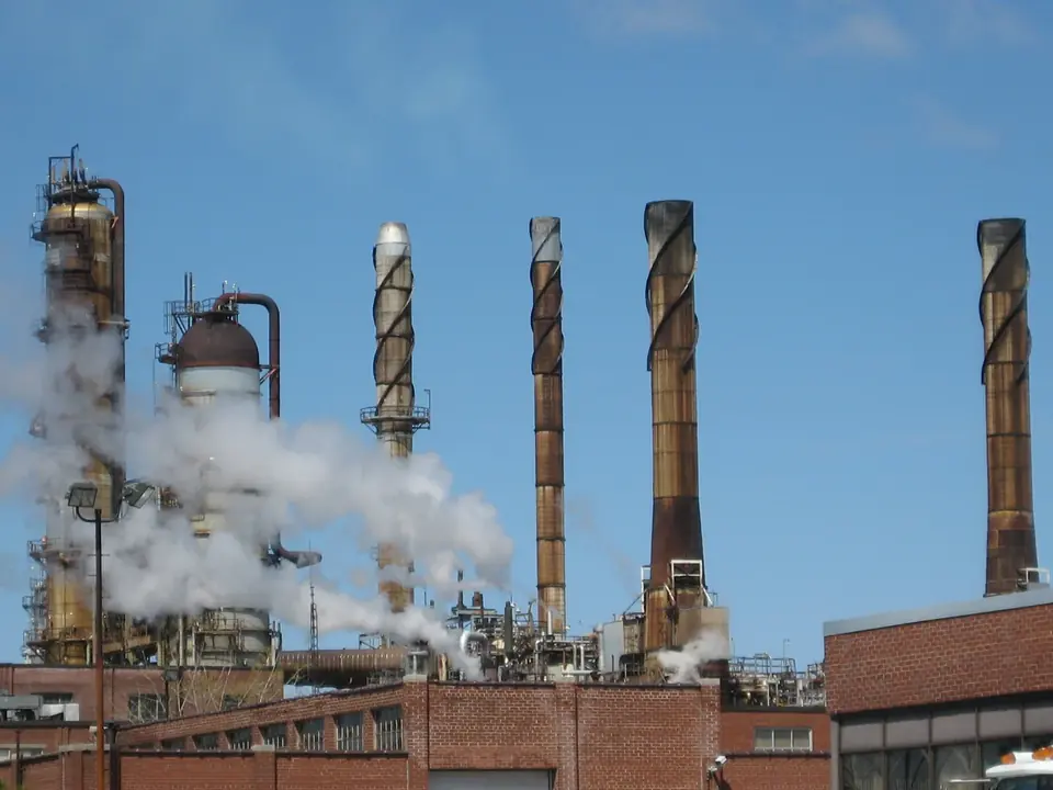Refinery distillation columns, stacks and connecting pipework under a blue sky